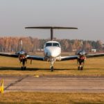 Small two-engine aircraft parked at the airfield